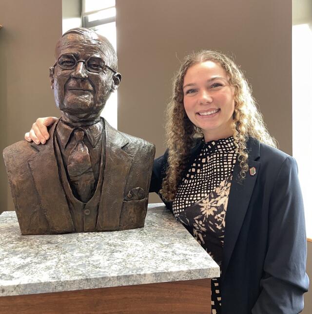 Bethany Baggett poses with the bronze bust of Edward S. "Beanie" Drake